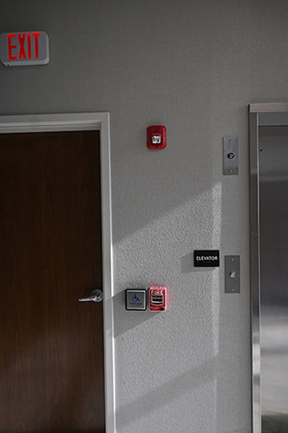 There is an exit sign on the wall next to the door.