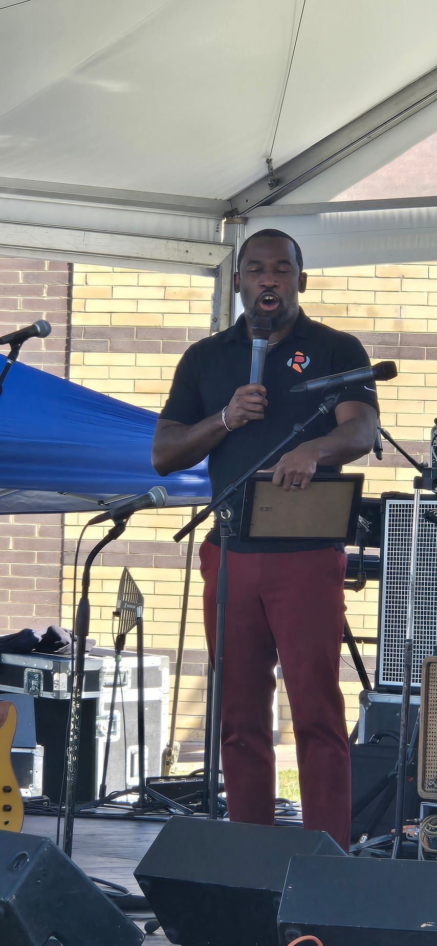 A man is standing on a stage holding a microphone.