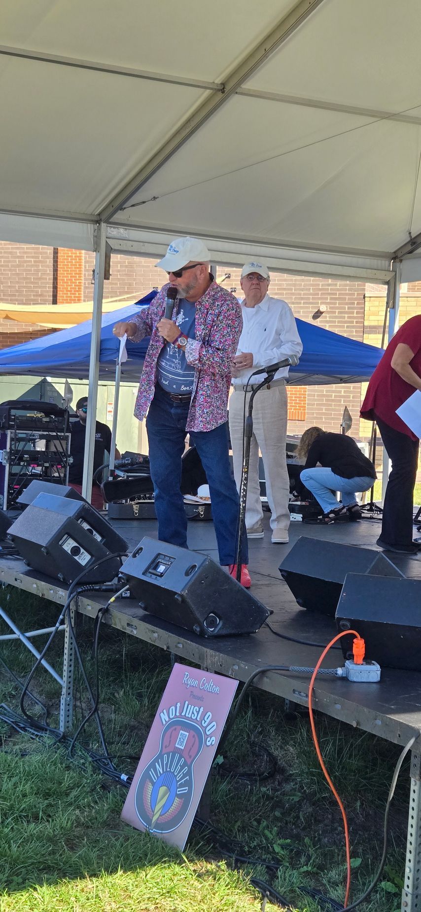 A man is standing on a stage holding a microphone.