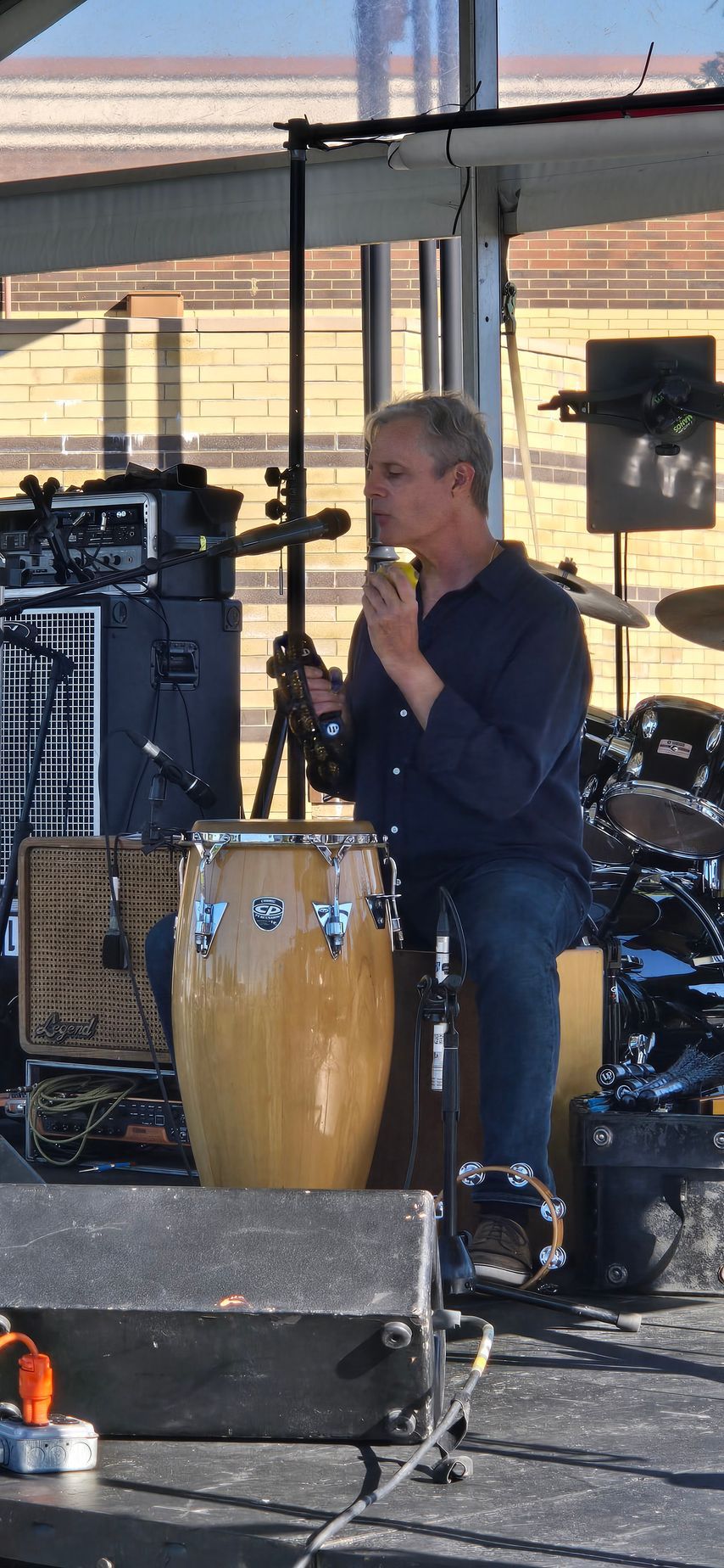 A man is playing a drum set on a stage.