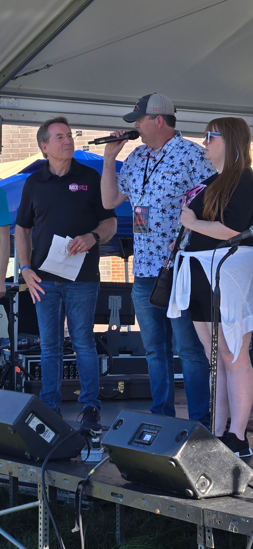 A group of people are standing on a stage holding microphones.