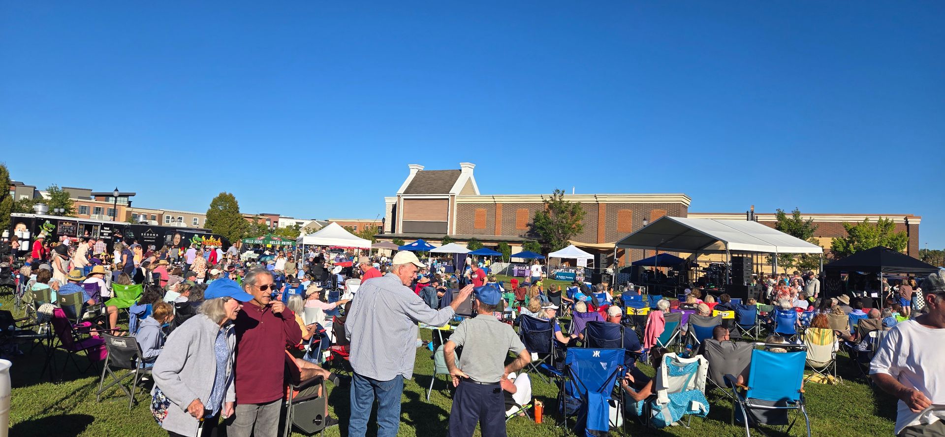 A large group of people are standing in a grassy field.