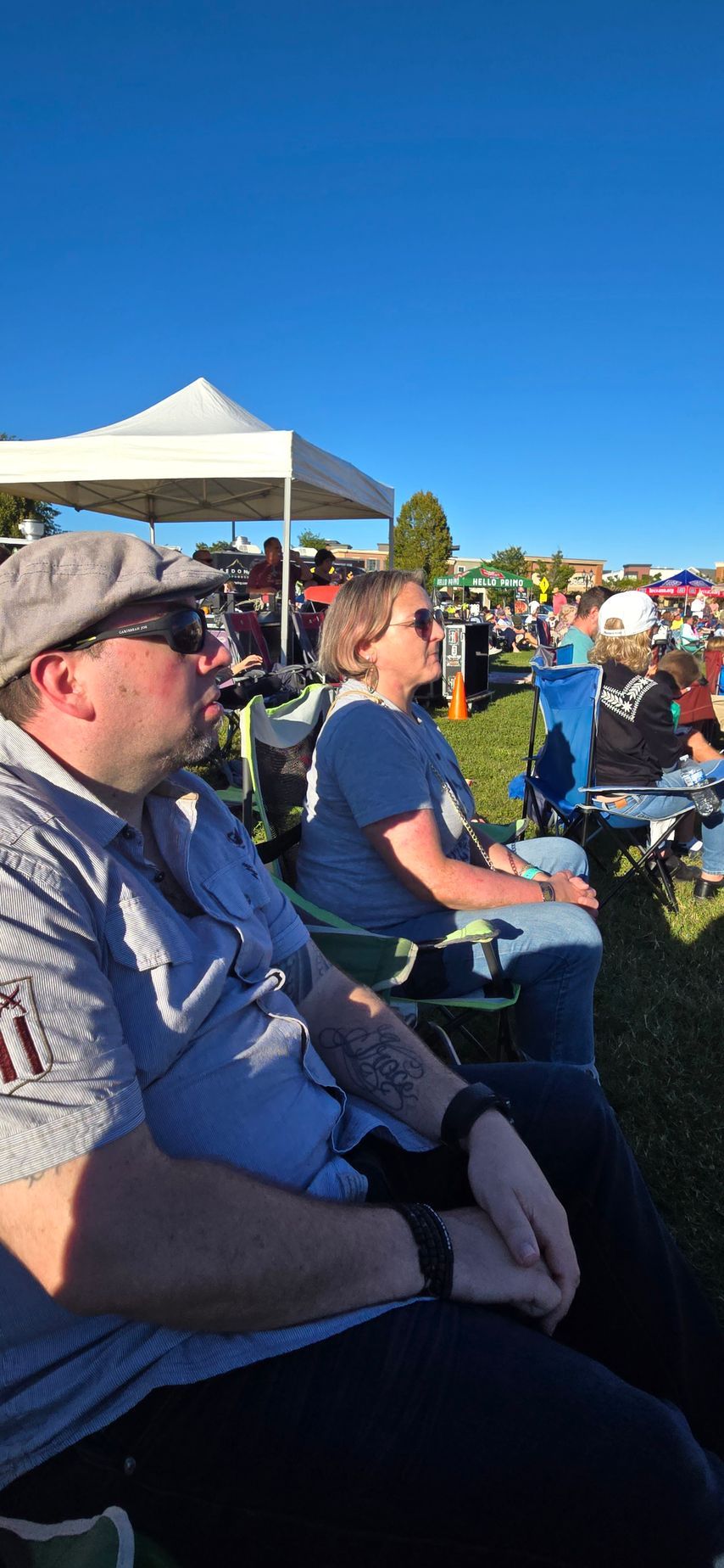 A man and a woman are sitting in chairs at a concert.