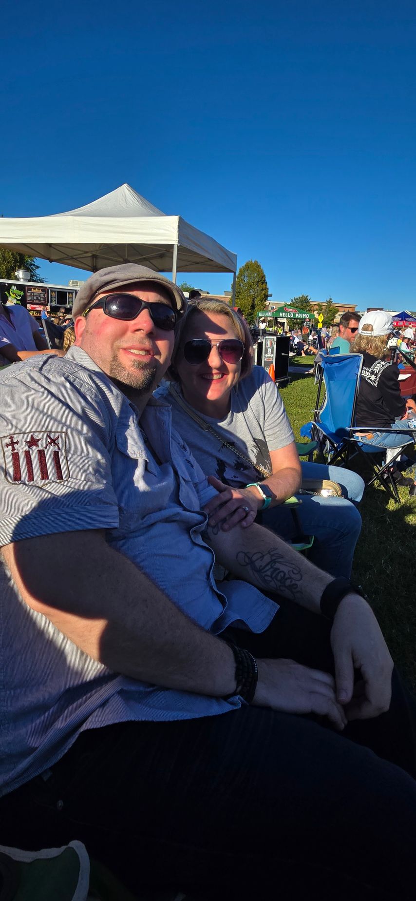 A man and a woman are sitting next to each other in a field.