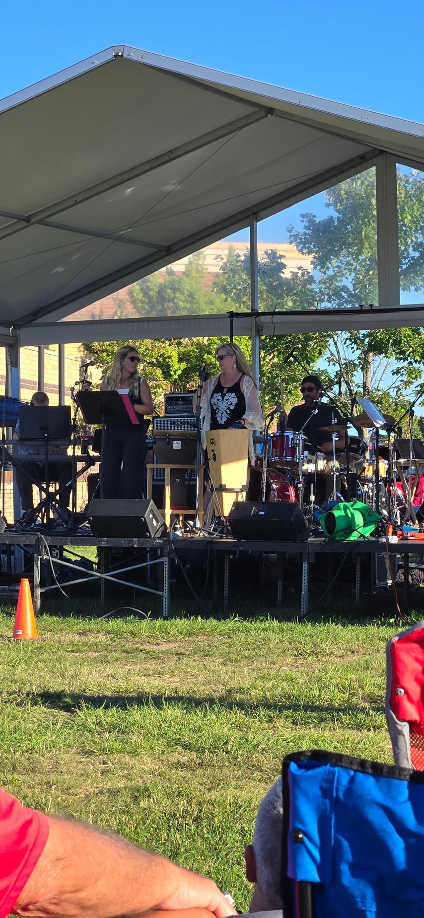 A group of people are standing on a stage under a tent.