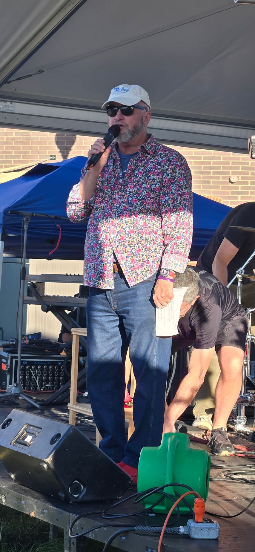 A man is standing on a stage holding a microphone.