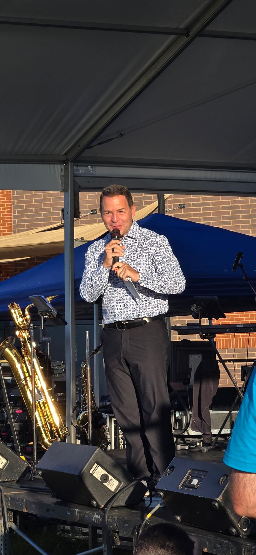 A man is standing on a stage holding a microphone.