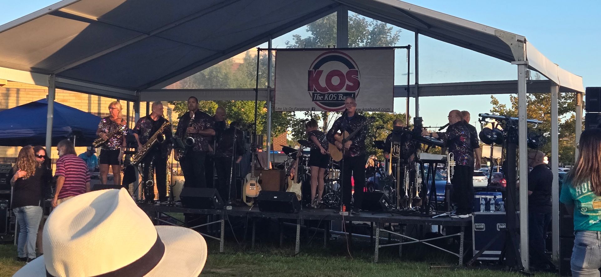 A man in a hat is standing in front of a stage with a band on it.