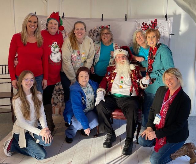 A group of people posing for a picture with santa claus