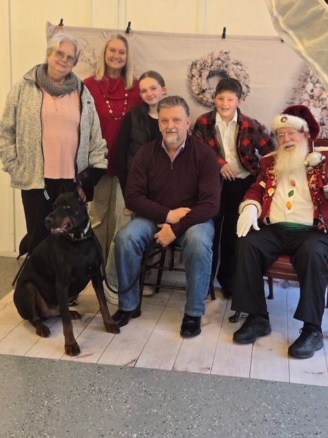 A group of people posing for a picture with santa claus