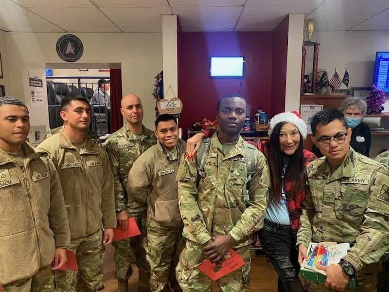 A group of soldiers are posing for a picture in a room.