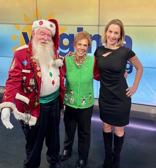 A man dressed as santa claus poses with two women