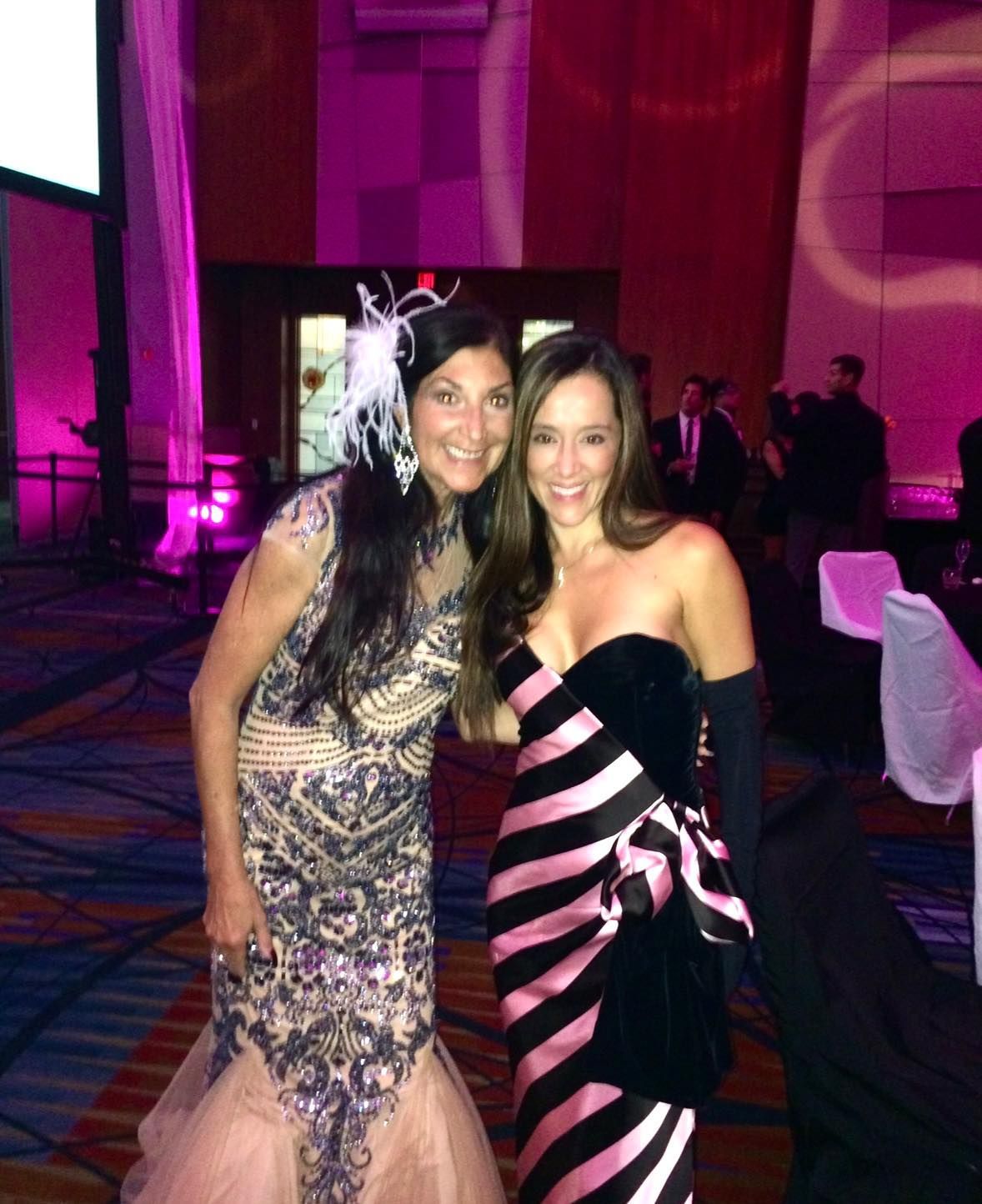 Two women posing for a picture in a room with purple lights