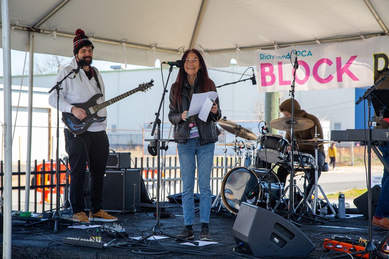 A man is playing a guitar and a woman is singing into a microphone.
