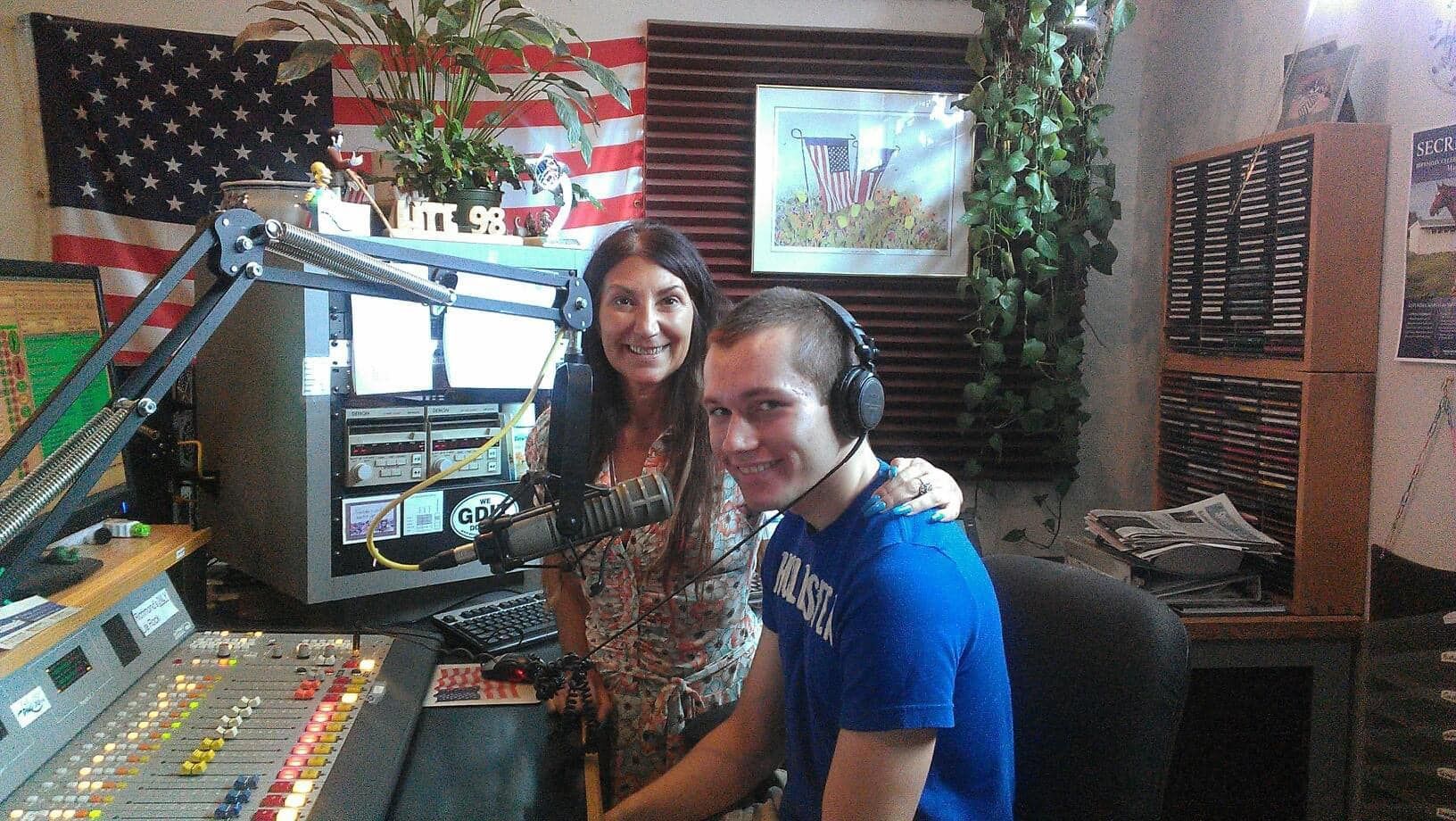 A man and a woman are posing for a picture in a radio studio