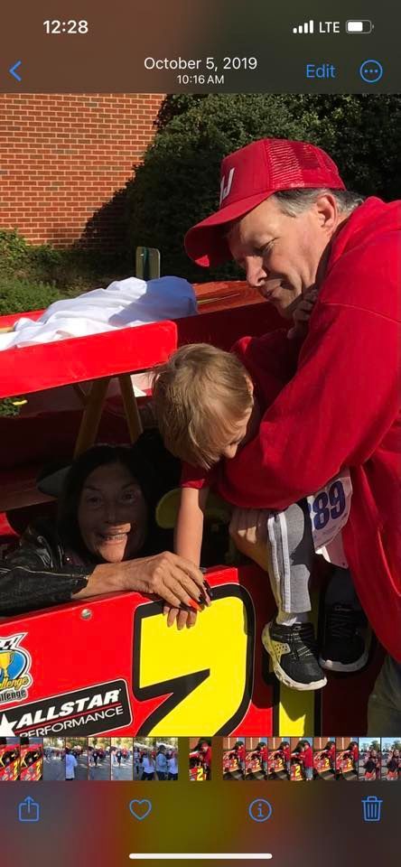 A man is holding a child in a race car.