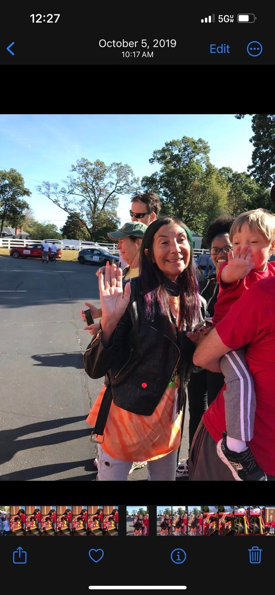 A group of people are standing next to each other in a parking lot.