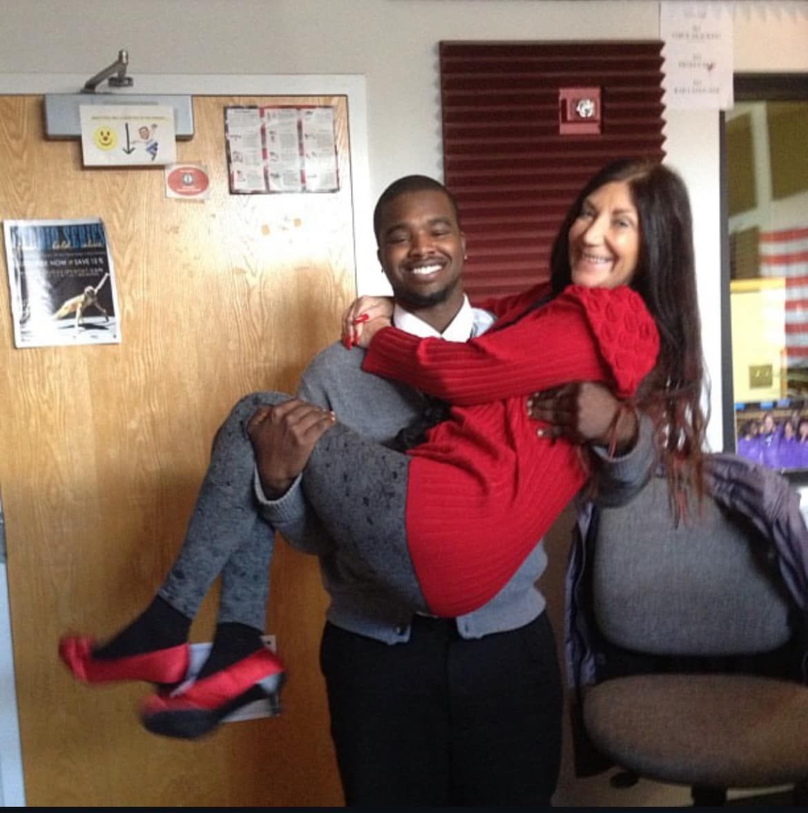 A man is carrying a woman in a red dress