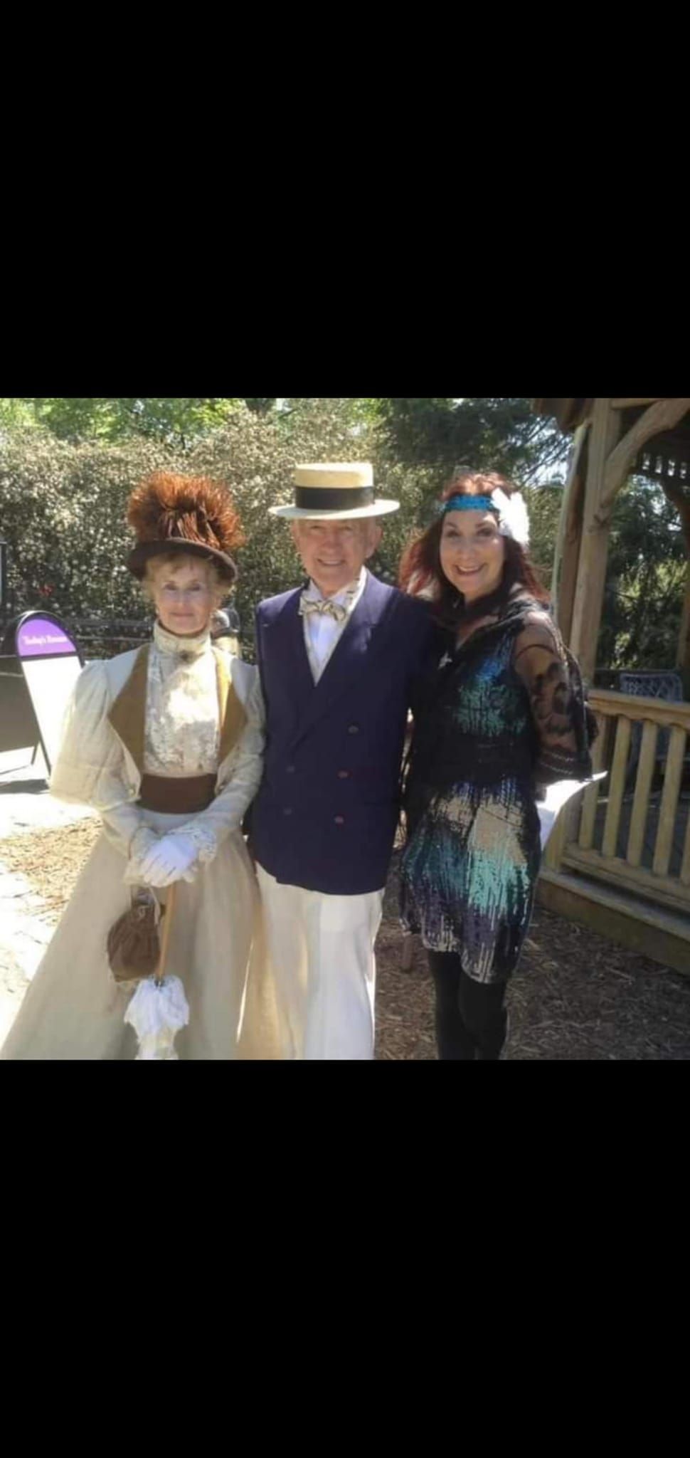 A man and two women are posing for a picture together.