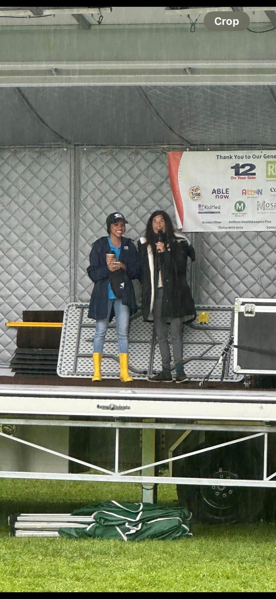 Two people are standing on a stage talking into microphones.