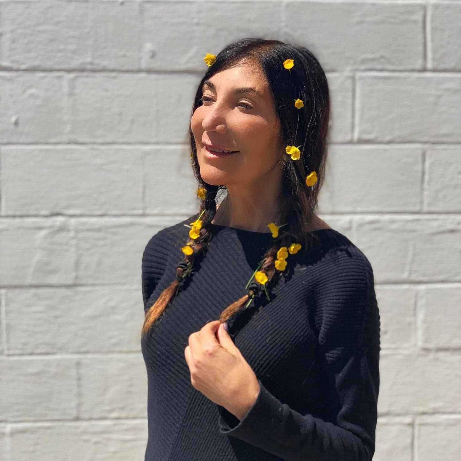 A woman with braids and yellow flowers in her hair
