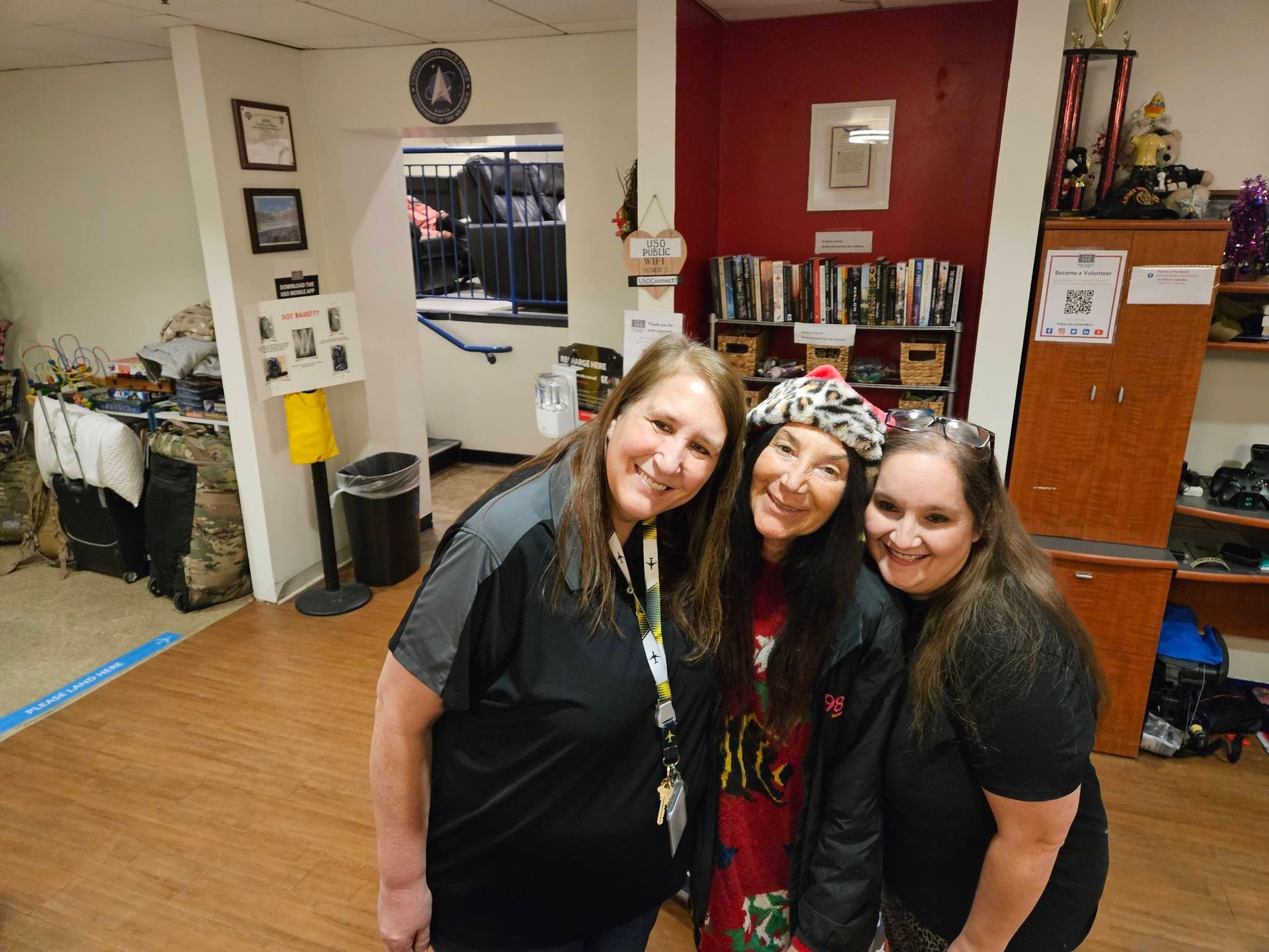 Three women are posing for a picture in a room.