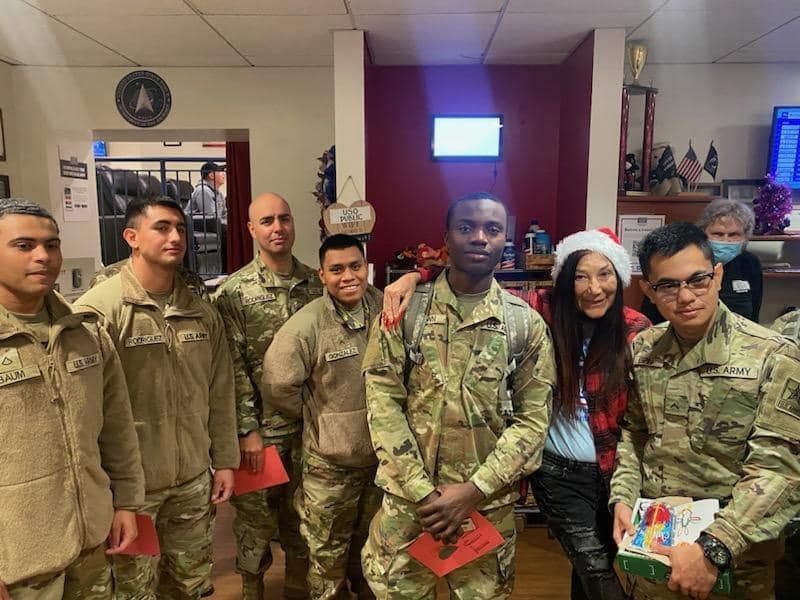 A group of soldiers are posing for a picture in a room.