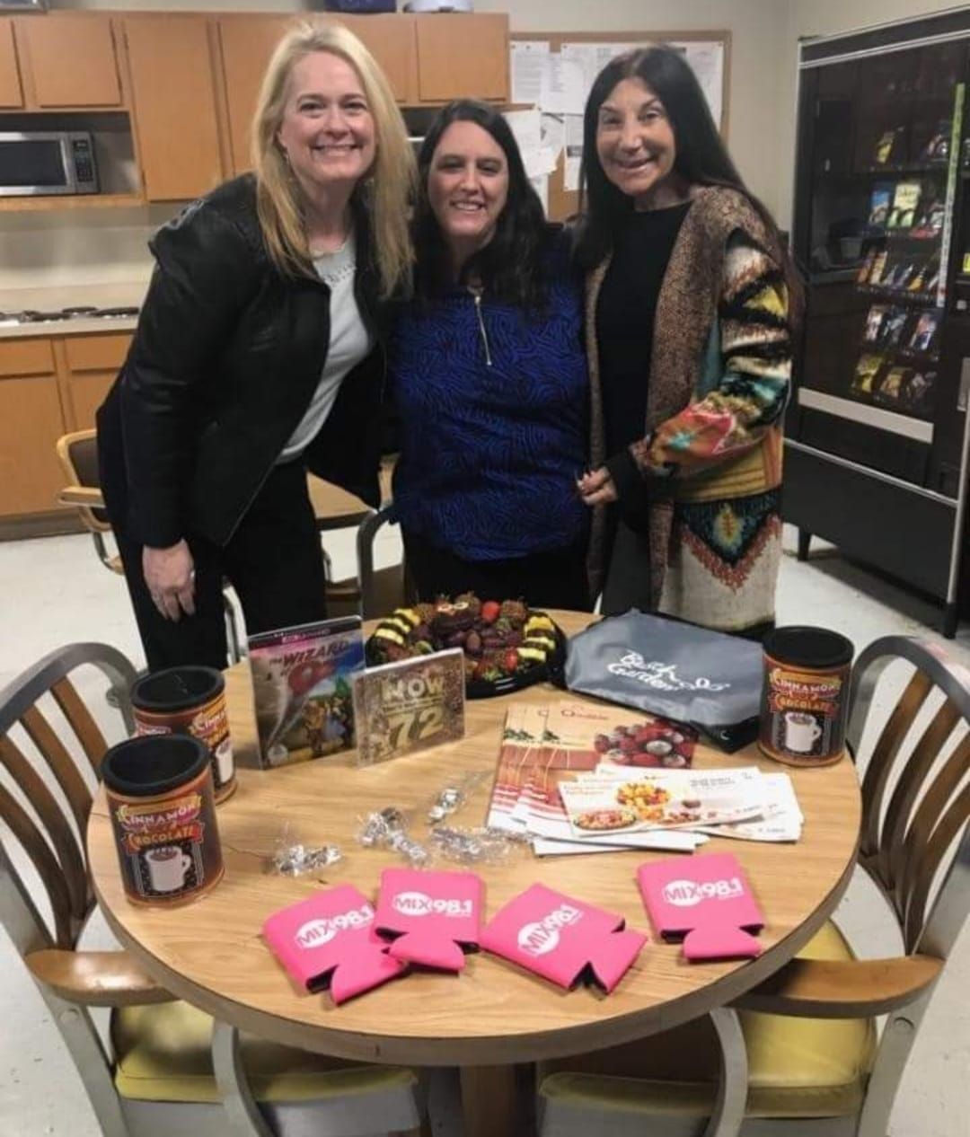Three women are posing for a picture at a table