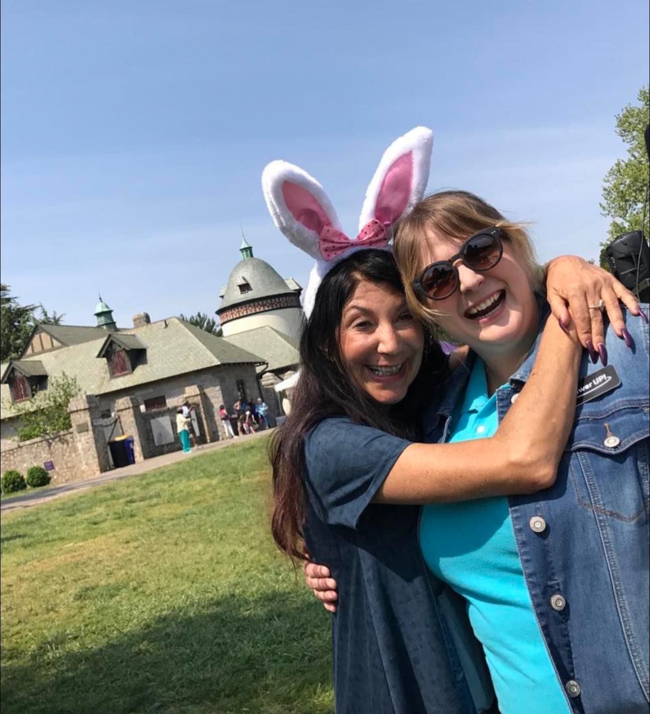 Two women posing for a picture with one wearing bunny ears