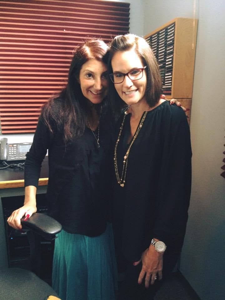 Two women are posing for a picture in an office