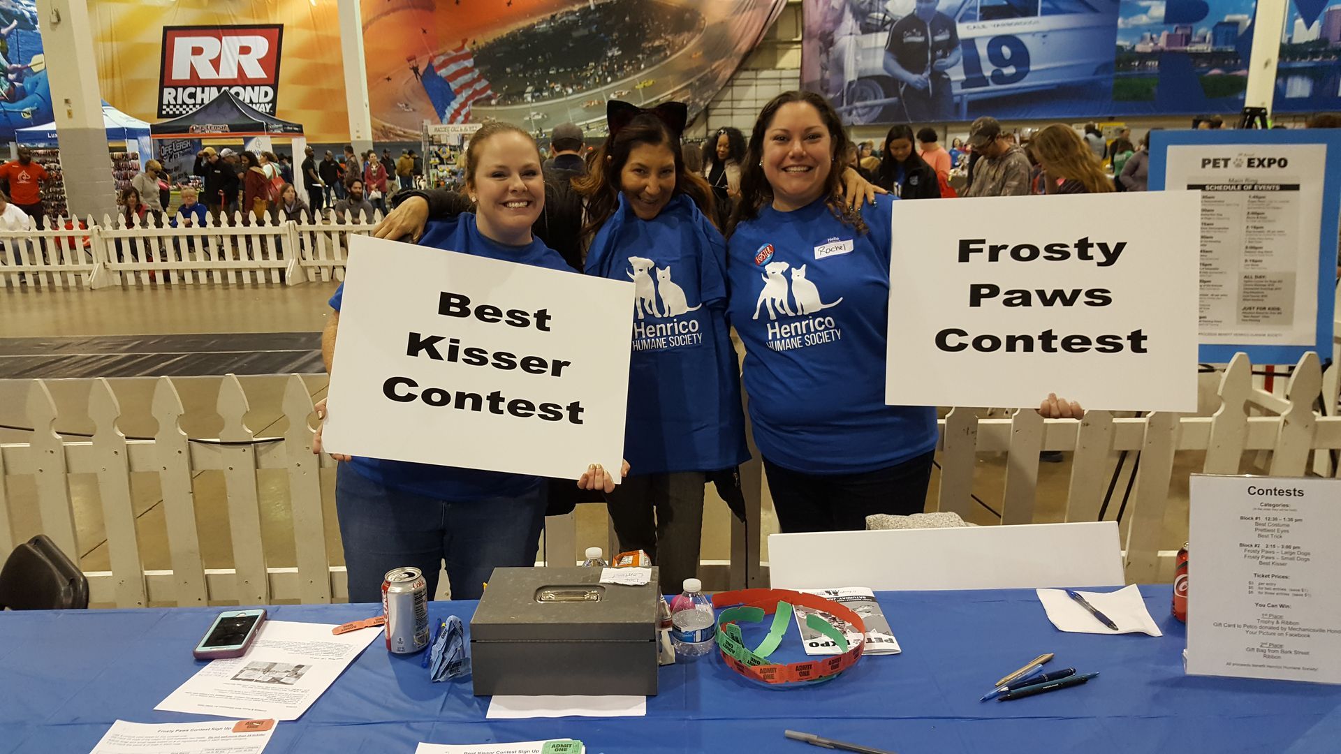 Three women holding signs that say best kicker contest and frosty paws contest