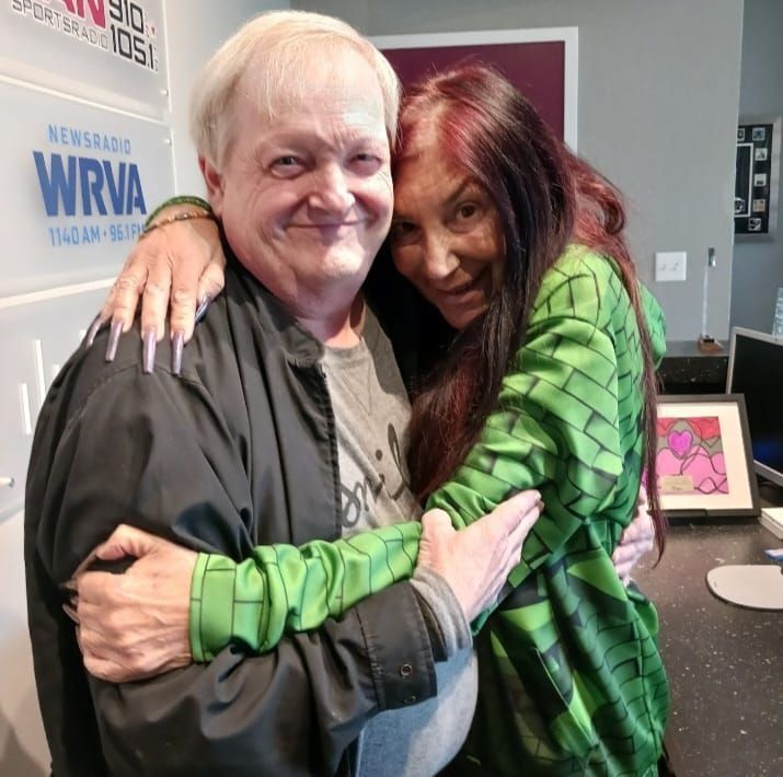 A man and woman hugging in front of a sign that says wrva