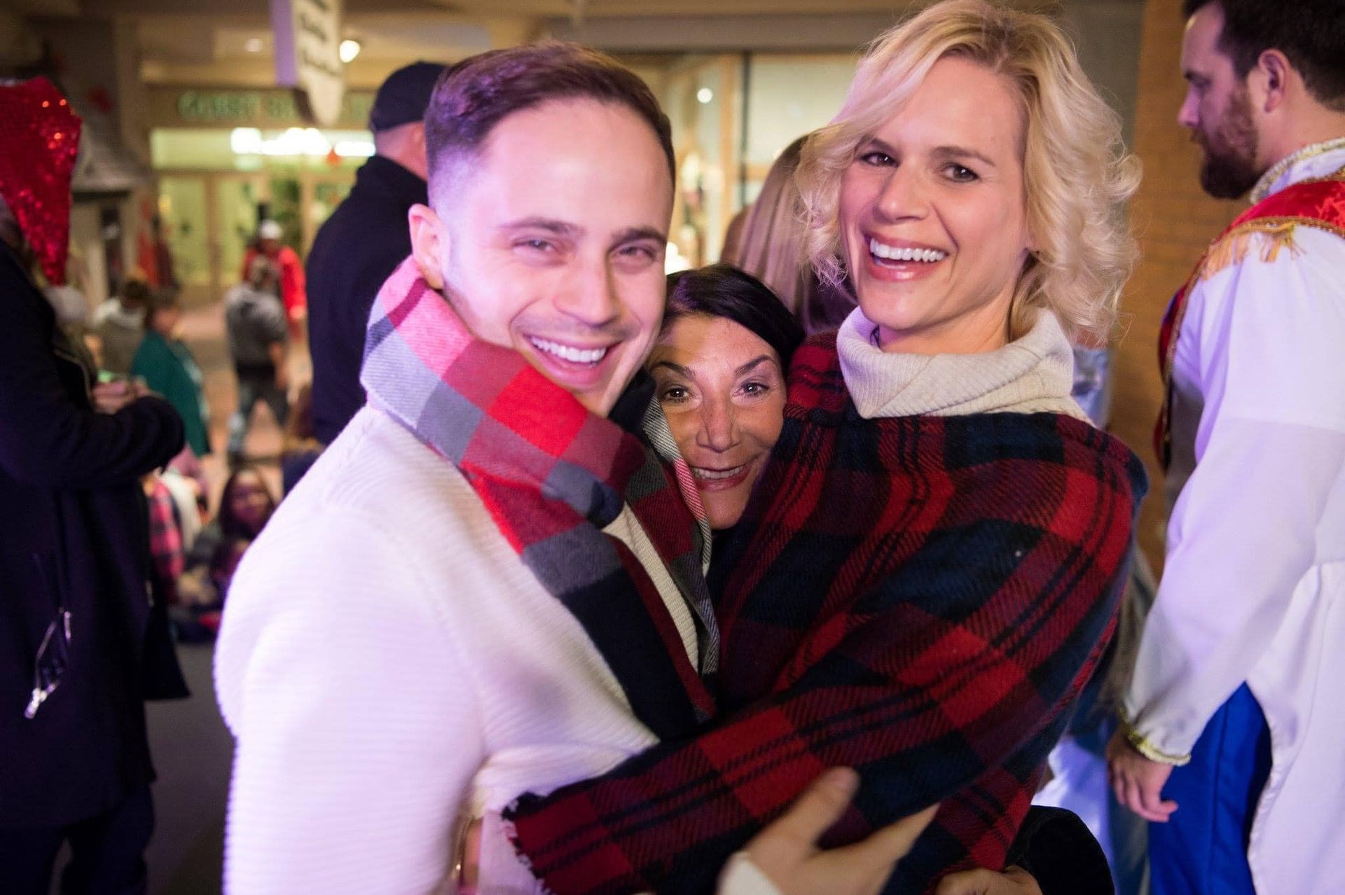 A man and a woman are hugging each other in a crowd of people.