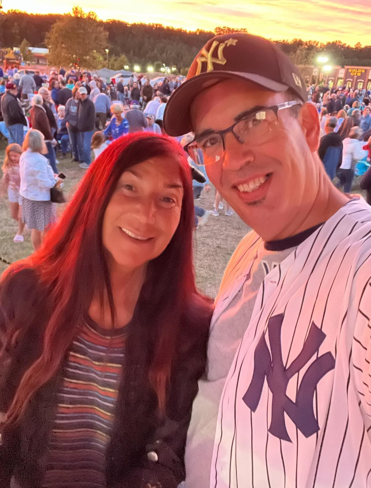 A man wearing a ny yankees jersey poses with a woman