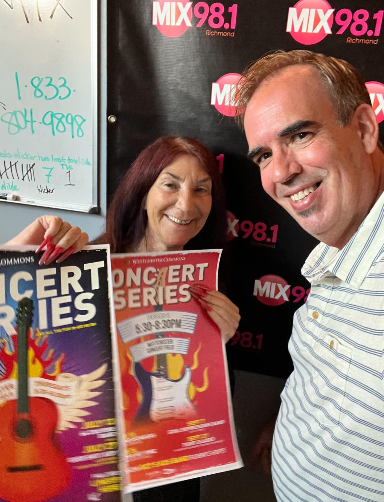 A man and a woman holding concert series posters
