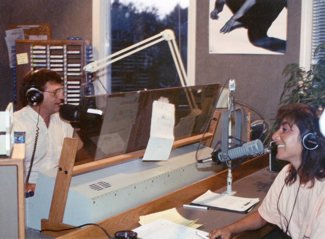 A man and a woman are sitting in front of a microphone