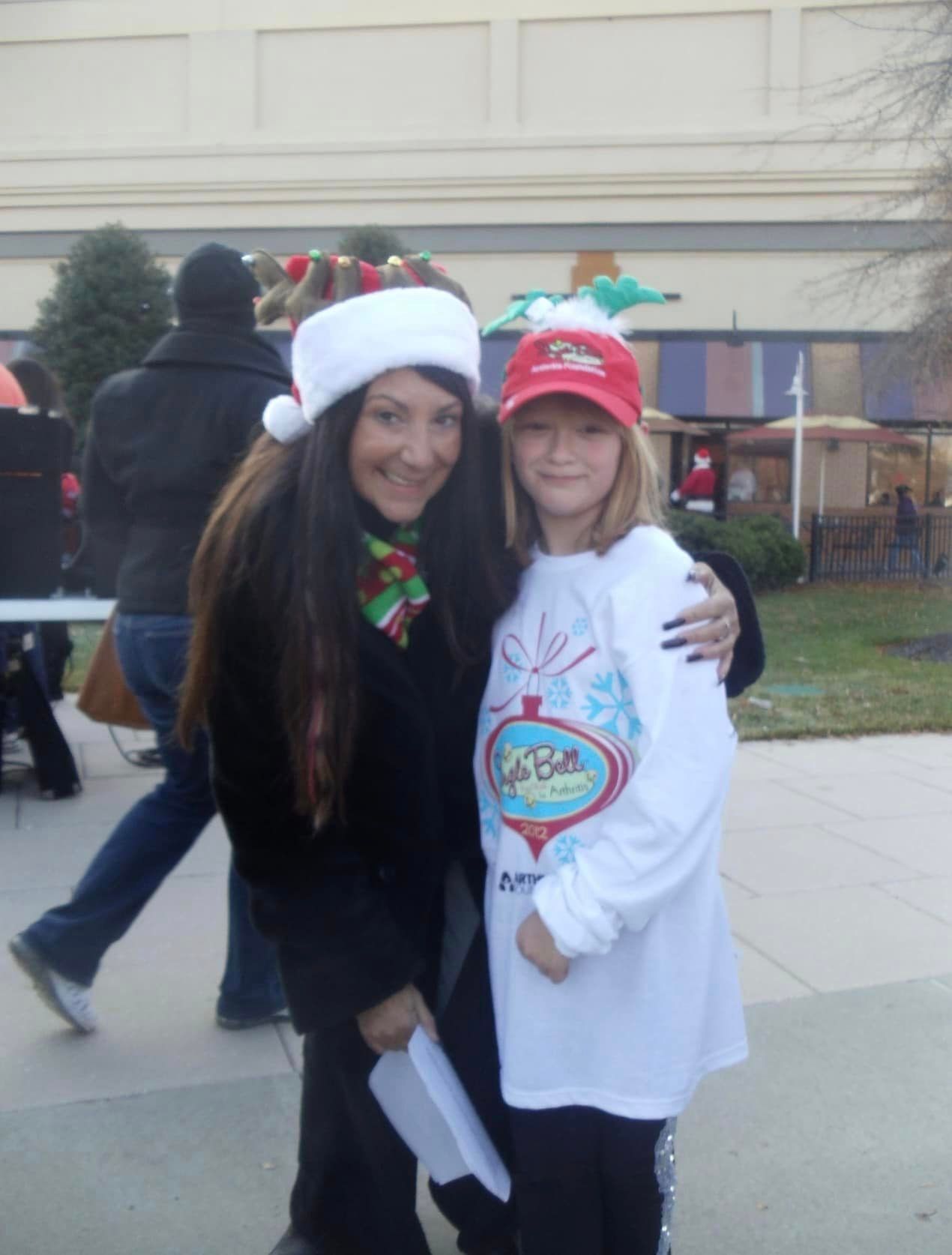 Two people posing for a picture with one wearing a santa hat