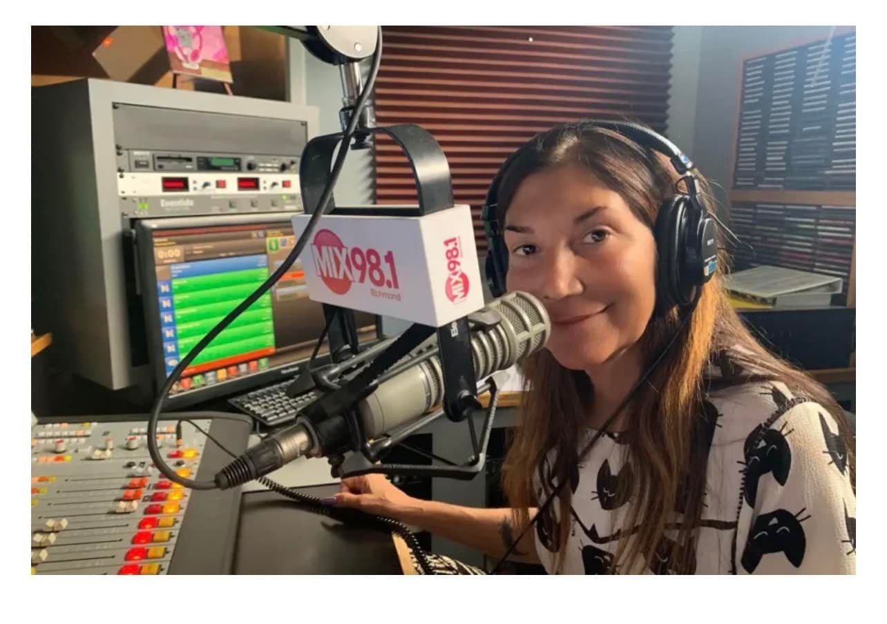 A woman wearing headphones is standing in front of a microphone that says 108.1