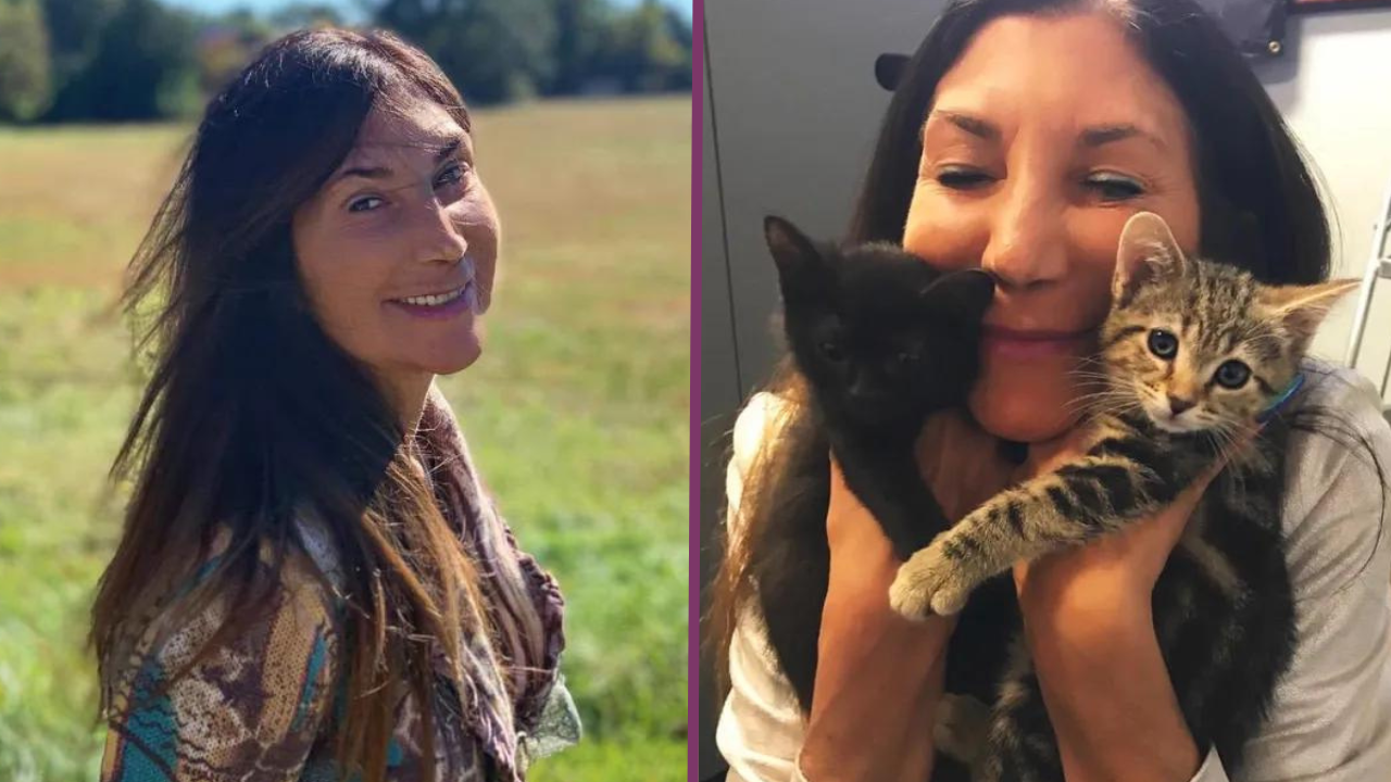 A woman is holding a kitten in her arms and smiling.