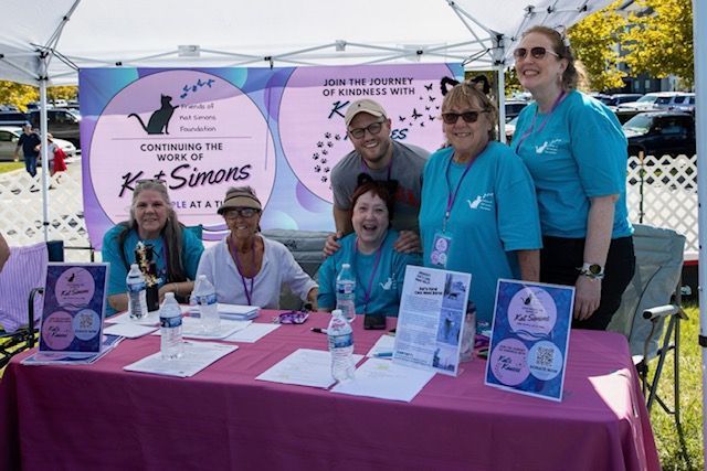 A group of people are standing around a table.