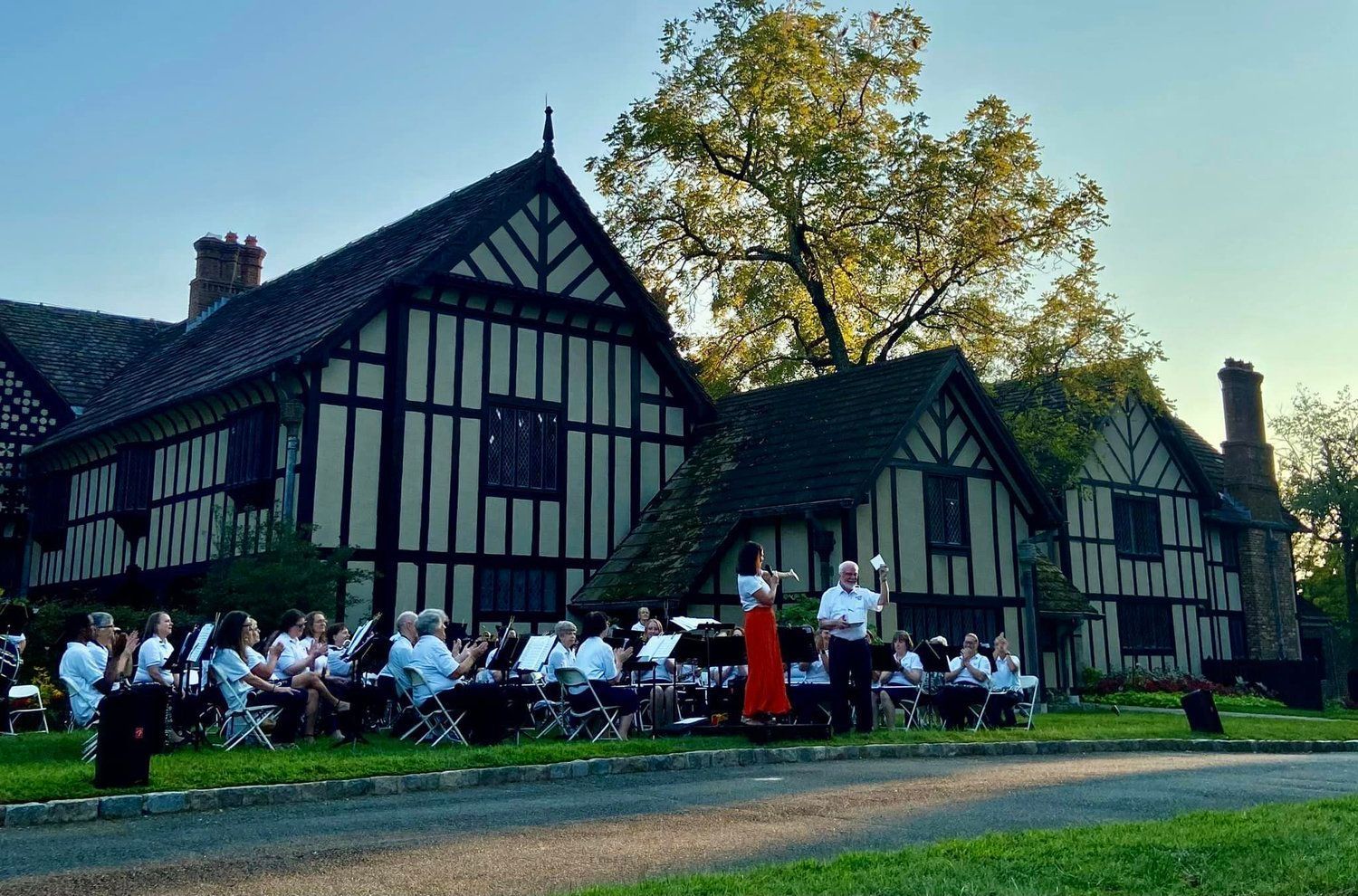 A group of people are sitting in front of a large building.