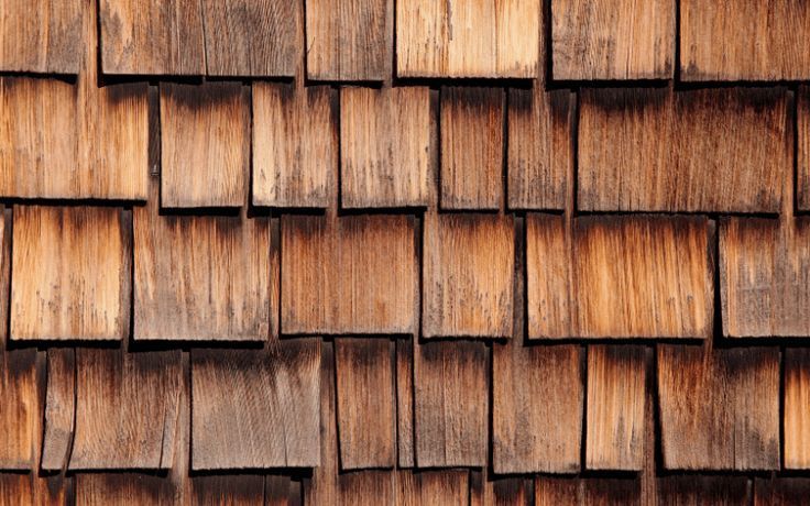 Wooden shingles, varying shades of brown, arranged in overlapping rows.