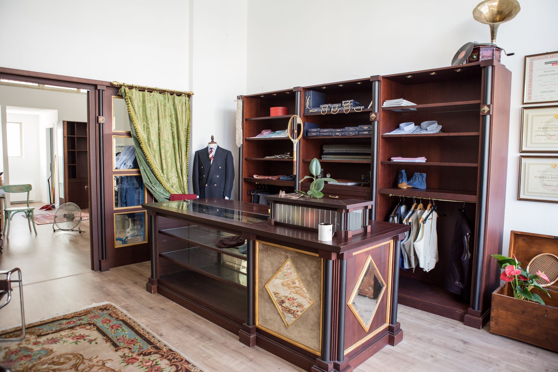 un manichino indossa un gilet grigio in una stanza accanto a un grammofono nella Sartoria uomo di Verona