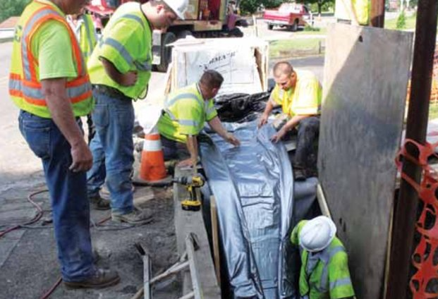 A group of construction workers are working on a pipe
