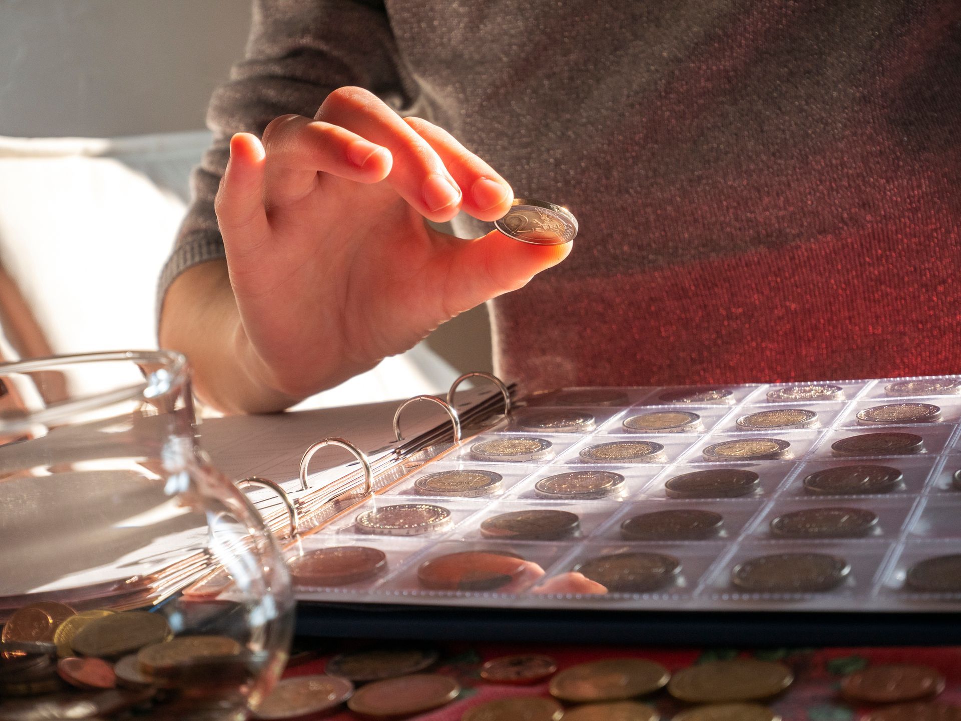 A person is putting a coin in a binder