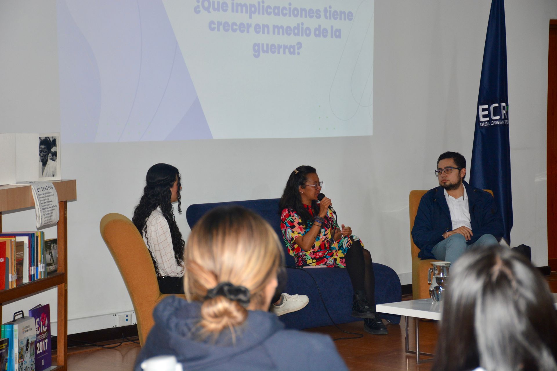 A group of people are sitting on a couch in front of a projector screen.