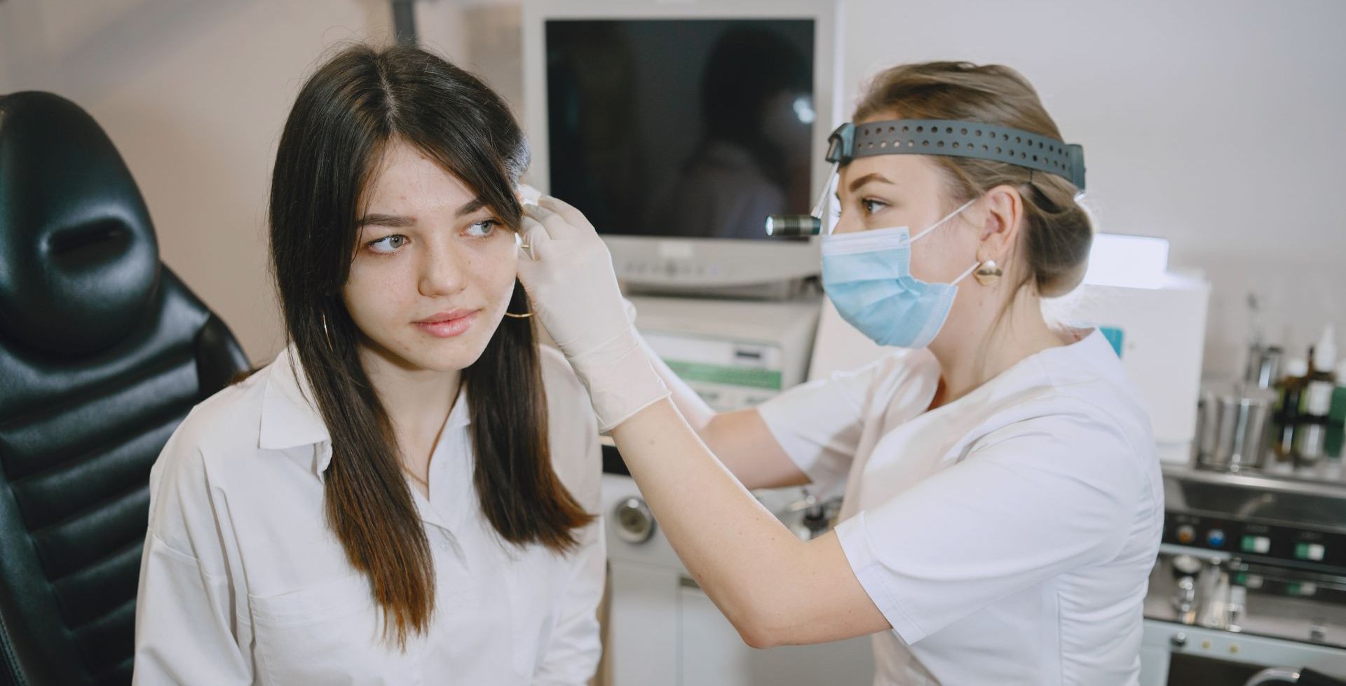 Una doctora examina el oído de un paciente en un hospital.