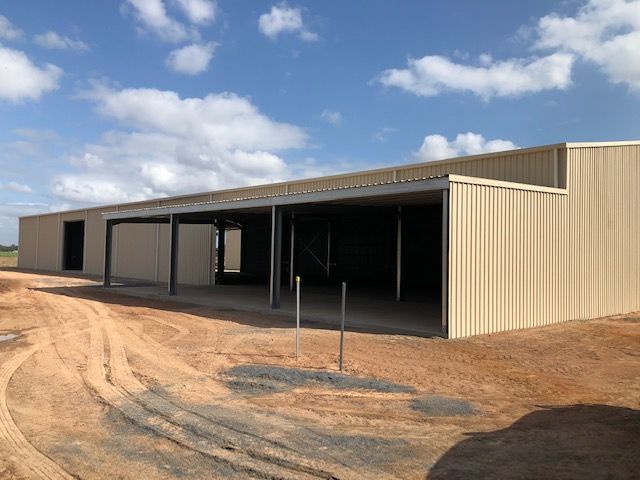 A Large Building Is Being Built In The Middle Of A Dirt Field — Shed Constructions (QLD) In Gin Gin, QLD