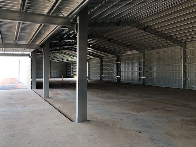 A Large Empty Warehouse With Concrete Floors And Columns — Shed Constructions (QLD) In Gin Gin, QLD