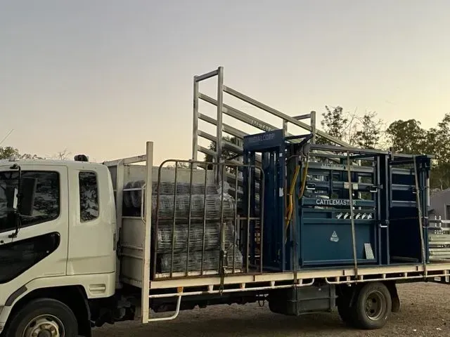 A White Truck With A Cage On The Back Is Parked In A Parking Lot — Shed Constructions (QLD) In Gin Gin, QLD